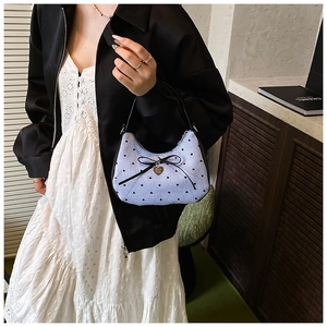 Détail du sac à bandoulière en velours côtelé bleu clair avec imprimés cœurs et nœud noir