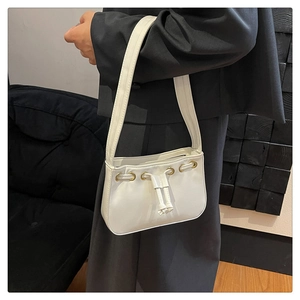 Detail of white leather shoulder bag with gold eyelets and drawstring decor on grey blazer