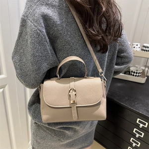 Fashionable macaron beige shoulder bag with top handle and gold hardware on model