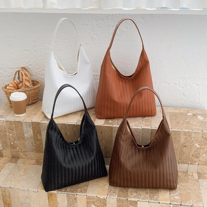 Retro woven texture large tote bags in four colors displayed on stone steps