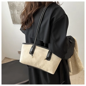 Détail de la bandoulière nouée et des surpiqûres contrastées sur le grand sac beige