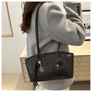 Détail du sac cabas gris avec breloque raquette de tennis et logo embossé Fashion