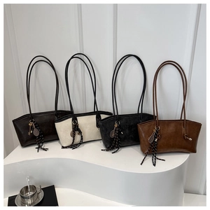 Détail de quatre sacs fourre-tout colorés avec de longues bandoulières et pendentifs