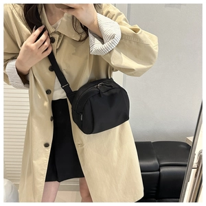 Minimalist black shell crossbody bag with adjustable strap shown on model for daily commute