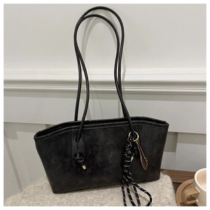 Détail d'un sac cabas vintage avec texte gaufré et pendentif de raquette de tennis