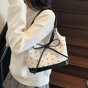 Sac sous le bras chic avec nœud papillon en tissu texturé blanc et cuir verni noir