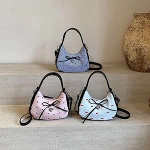 Trois sacs à bandoulière avec nœuds et breloques cœur en violet, rose et blanc à pois