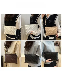 Detailed views of the embossed envelope handbag worn as a clutch and shoulder bag