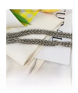 Close-up of silver woven metal chain strap with intricate mesh link texture on bag