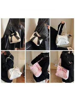 Detail of shoulder bag featuring textured bubble fabric and large decorative bow design