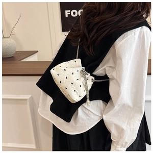 Detailed view of white quilted mini bucket bag with rabbit print and pearl chain