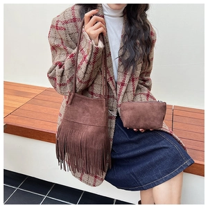 Bolso saco retro de ante marrón con flecos y estuche a juego en una modelo de moda