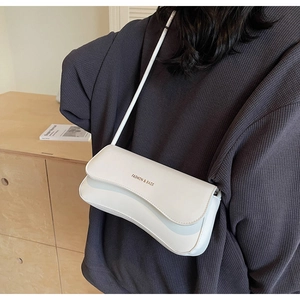 Detailed shot of white faux leather crossbody bag with gold FASHION & BAGS lettering