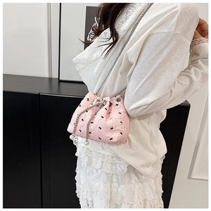 Detail of pink quilted bucket bag with black patterns and elegant pearl drawstring