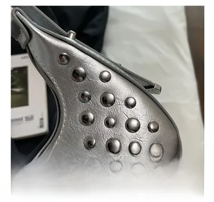 Dettaglio della borsa metallizzata argento con borchie e texture pelle screpolata