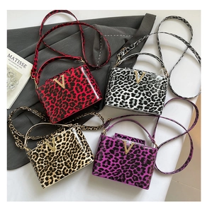 Assorted glossy leopard print handbags in four colors featuring golden V-shaped metal buckles