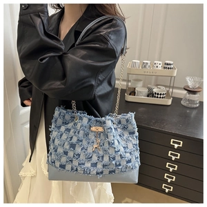 Détail du sac fourre-tout en denim patchwork bleu avec bords effilochés et pendentif