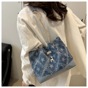 Détail du sac cabas en denim à motif d'étoiles avec bords effilochés et pendentif cerf