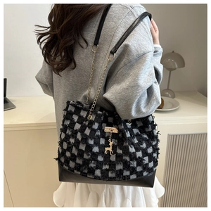 Détail du sac cabas à carreaux avec franges, pendentif cerf et bandoulière chaîne