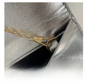 Gros plan sur le sac en cuir argenté texturé avec détails de chaîne en métal doré