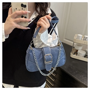 Dettaglio della borsa a spalla in denim con catena metallica e fibbia decorativa