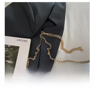 Détail de la bandoulière en chaîne dorée élégante sur un sac à bandoulière minimaliste