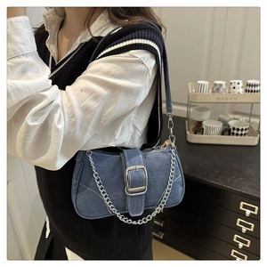 Dettaglio della borsa baguette in denim blu con fibbia argentata e catena in stile lifestyle