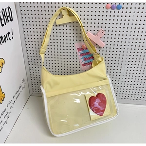 Détail du sac bandoulière jaune clair avec poche PVC transparente et carte de cœur