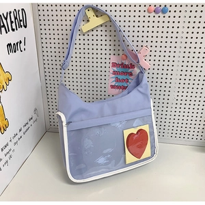 Détail du sac cabas en nylon lilas avec une poche transparente et une carte cœur