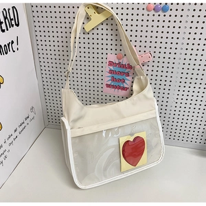 Détail d'un sac fourre-tout en toile crème avec une poche transparente en PVC à cœur