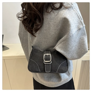 Dettaglio borsa in denim nero con fibbia argentata e cuciture bianche a contrasto