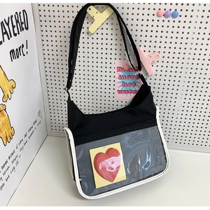 Détail du sac bandoulière en toile avec poche frontale en PVC transparent et carte