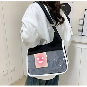 Gros plan du sac messager en toile noire avec une poche en PVC transparent et carte rose