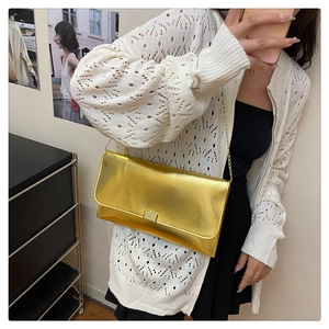 Detail of a chic gold rectangular crossbody bag featuring a metallic finish and chain strap