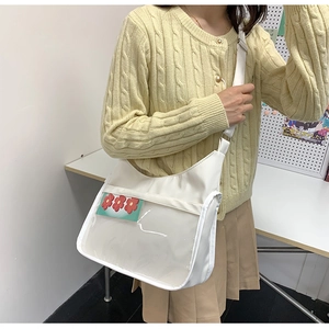 Gros plan sur un sac à bandoulière blanc avec fenêtre PVC transparente et sangle réglable