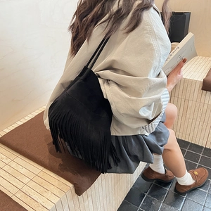 Retro black tassel shoulder bag for women with minimalist bucket style and sleek strap