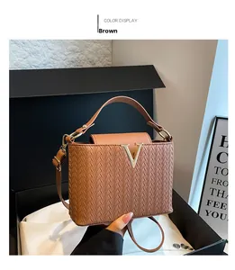 Close-up of the brown woven texture and gold V buckle on the leather square bag