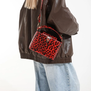 Sac bandoulière tendance à imprimé léopard rouge avec boucle V dorée porté