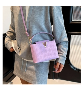 Détail du sac bandoulière lavande à texture tissée et boucle en métal doré en forme de V