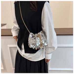 Detailed close-up of a silver sequin bucket bag with a gold chain strap and pearl decor