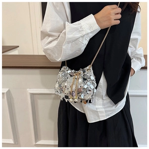 Detailed close-up of a silver sequin bucket bag with gold chain and white pearl pendant