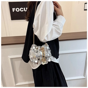 Détail d'un sac seau à paillettes argentées avec perle et bandoulière en chaîne dorée