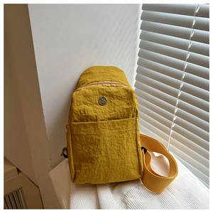 Détail du sac de poitrine en nylon jaune moutarde avec bandoulière large et logo M FASHION