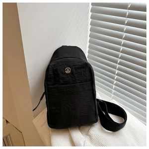 Détail du sac de poitrine en nylon noir imperméable avec logo M et fermeture éclair