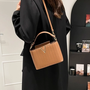 Brown woven texture handbag with gold V-shaped hardware and adjustable strap