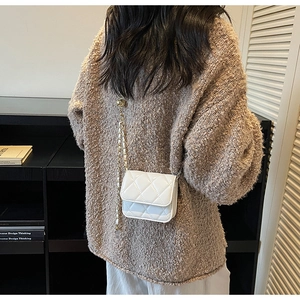 Mini sac bandoulière matelassé blanc brillant avec chaîne dorée porté par mannequin