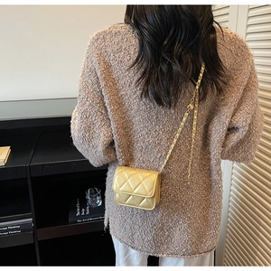 Vue détaillée d'un mini sac matelassé champagne avec bandoulière chaîne sur un mannequin
