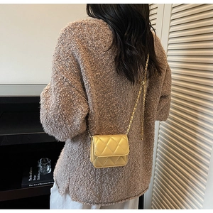 Vue détaillée du mini sac matelassé jaune avec chaîne dorée portée à l'épaule