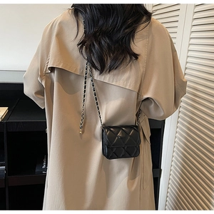 Détail de la bandoulière en chaîne sur un sac à bandoulière en cuir noir sur modèle