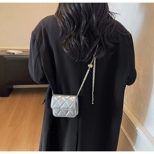 Détail du mini sac bandoulière argenté matelassé avec chaîne à boule réglable